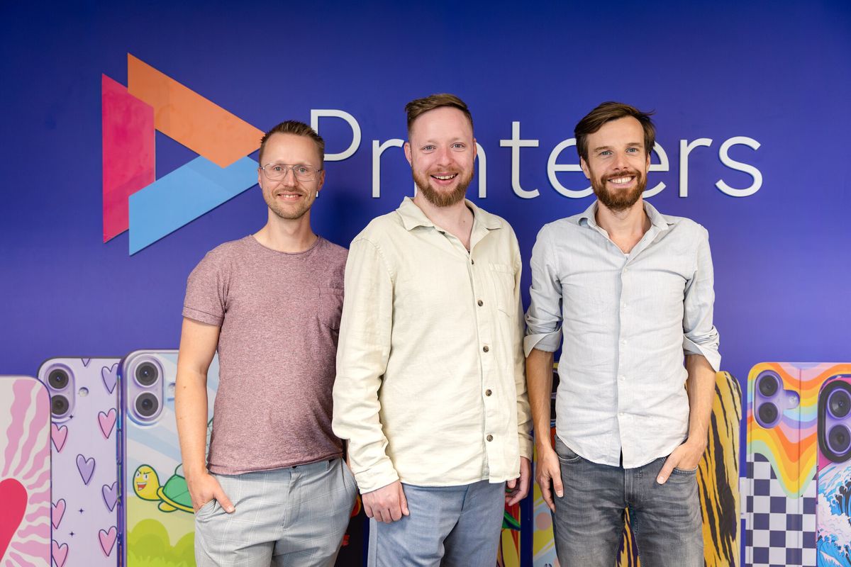 The three Printeers directors in front of the Printeers logo