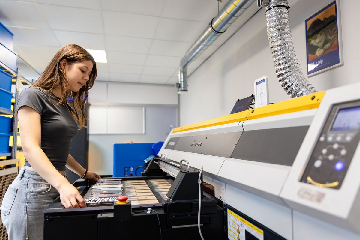 Phone cases being UV printed on a flatbed UV printer at Printeers